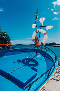 Ferris wheel in sea against clear blue sky