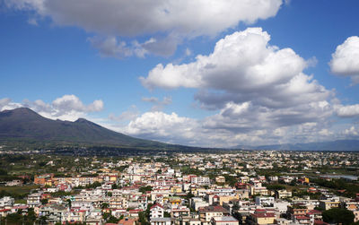 Aerial view of townscape and mountains against sky