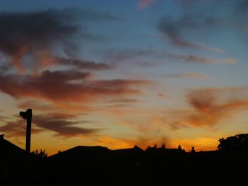 Low angle view of silhouette buildings against dramatic sky