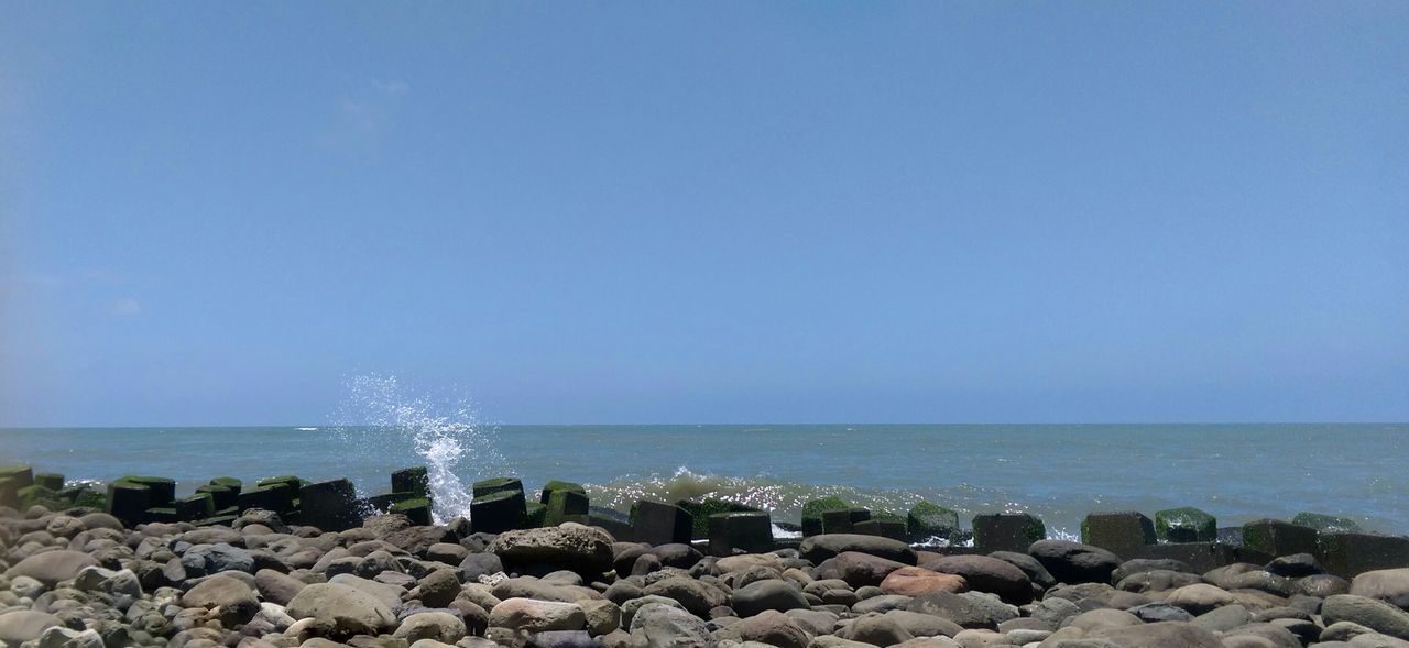 sea, horizon over water, water, beach, shore, scenics, clear sky, beauty in nature, rock - object, tranquil scene, copy space, tranquility, blue, nature, stone - object, sky, idyllic, pebble, wave, seascape