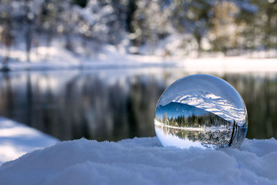 Reflection of trees on snow covered landscape