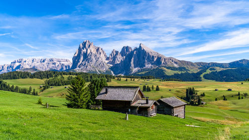 Wooden chalets in dolomites, odle mountains in the background of the seceda mountains