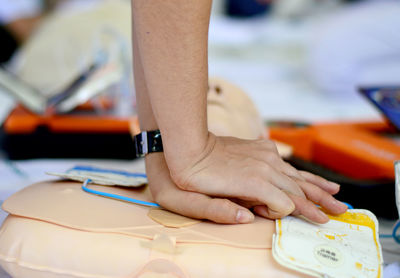 Cropped hands of man performing cpr on dummy