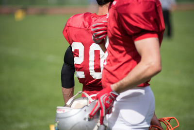 Midsection of players standing on field