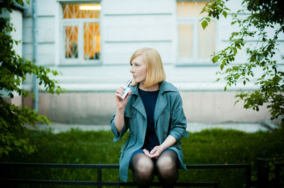 Full length of woman sitting on mobile phone