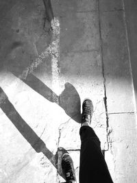 Low section of man standing on sidewalk