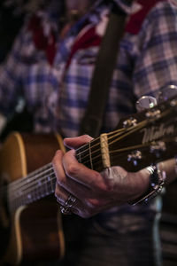 Midsection of musician playing electric guitar