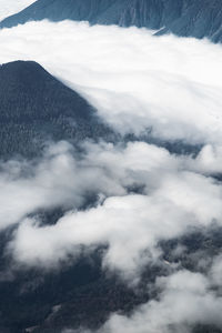 Scenic view of clouds covering mountains against sky