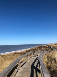 Scenic view of beach against clear blue sky