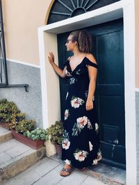 Woman standing by flower pot