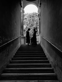 Rear view of man walking on staircase