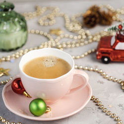 Cup of espresso with crema and christmas decoration. drinking coffee in winter holidays and coffee