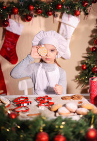 Portrait of cute girl decorating christmas tree at home