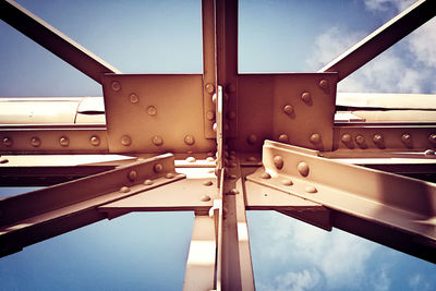 Close-up of metal structure against blue sky