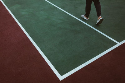 Low section of person standing on tennis court.