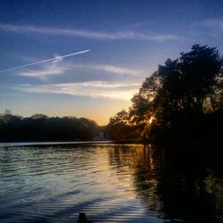 Scenic view of river against sky at sunset