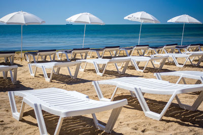 Beautiful empty beach with rows of sun beds under straw umbrellas