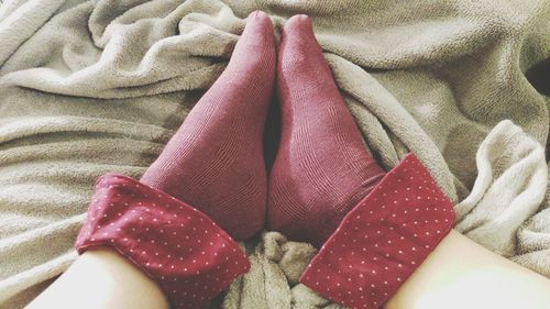 Low section of man relaxing on bed