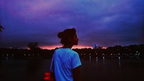 Man standing on illuminated city against sky at night