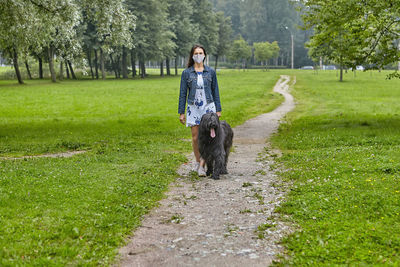 Full length of woman with dog on grass