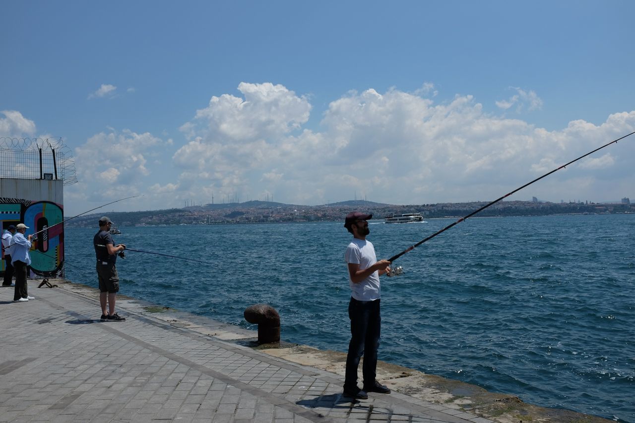 YOUNG WOMAN STANDING ON JETTY