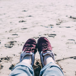 Low section of man standing on beach