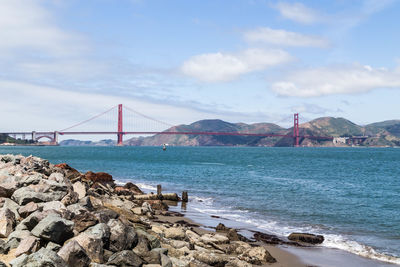 View of suspension bridge over sea against sky