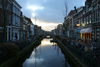 Canal amidst city against sky