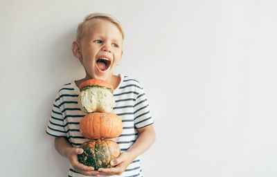 Portrait of cute girl eating food against white background