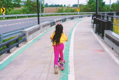 Rear view of woman walking on road