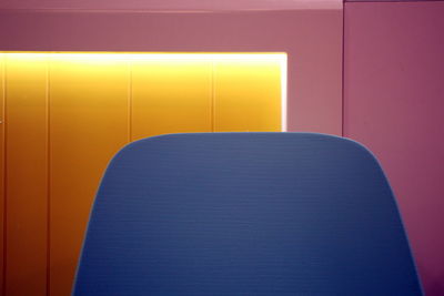 Close-up of empty chair against wall at home
