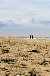 People at beach against sky