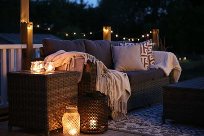 Illuminated lanterns by sofa at home