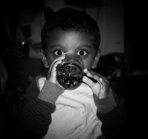Close-up portrait of boy holding camera