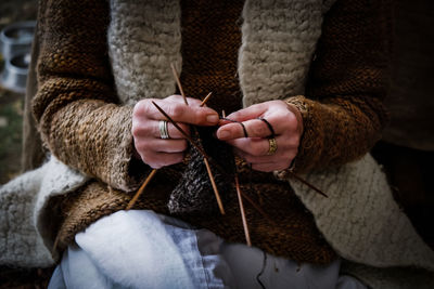 Midsection of person knitting sweater