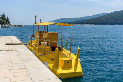 Yellow tourist submarine boat at dock in rabac, croatia