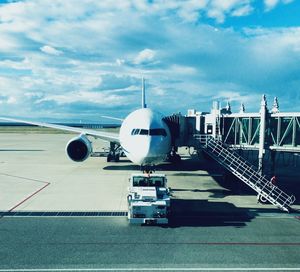 Airplane on airport runway against sky