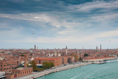 View of buildings in city against cloudy sky