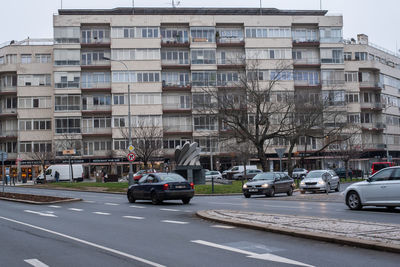 Cars on street by buildings in city