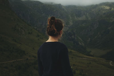 Rear view of woman standing on mountain