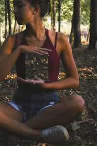 Young woman sitting in forest