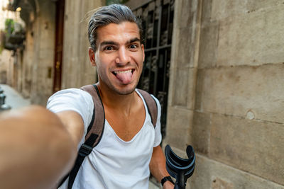 Selfie of young latin man with crutches in the street