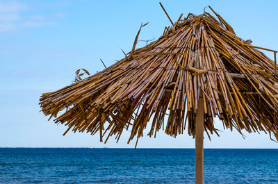 Low angle view of parasols on beach against clear sky