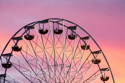 Low angle view of ferris wheel against sky during sunset