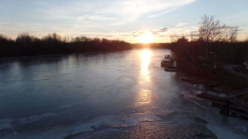 Scenic view of frozen lake against sky during sunset