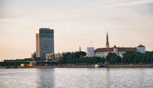 River by buildings against sky in city