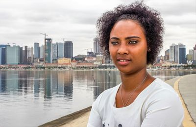 Close-up of smiling young woman by lake