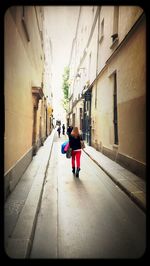 Rear view of woman walking in alley