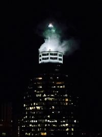 Low angle view of illuminated buildings against sky at night