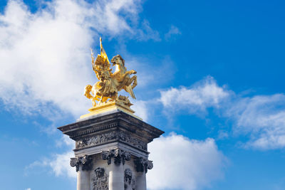 Low angle view of statue against cloudy sky